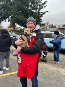 A Humane Society for Southwest Washington volunteer holds the dog of a participant of Project Homeless Connect 2025.